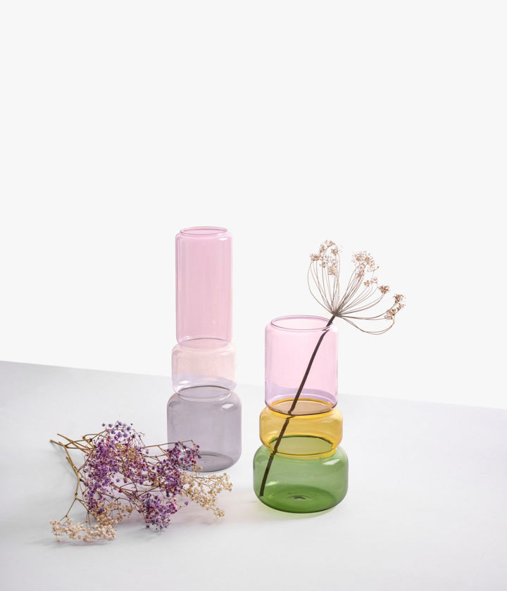 Vasi Revolve di Ichendorf in vetro borosilicato, nelle varianti di colore rosa, grigio, ambra e verde, con dettagli di fiori secchi.