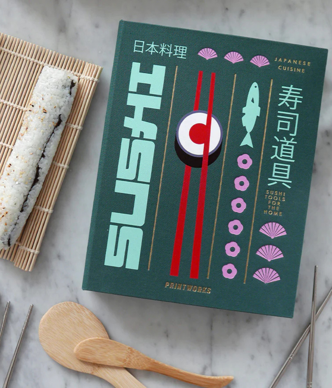 Scatola con Design a libro per preparare sushi.  Sushi di riso su tovaglietta in bambù. Sfondo marmo